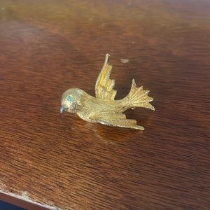 Yellow gold bird pin with blue crystal eye